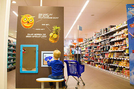 This picture shows a boy playing at the Albert Heijn kids corner supermarket